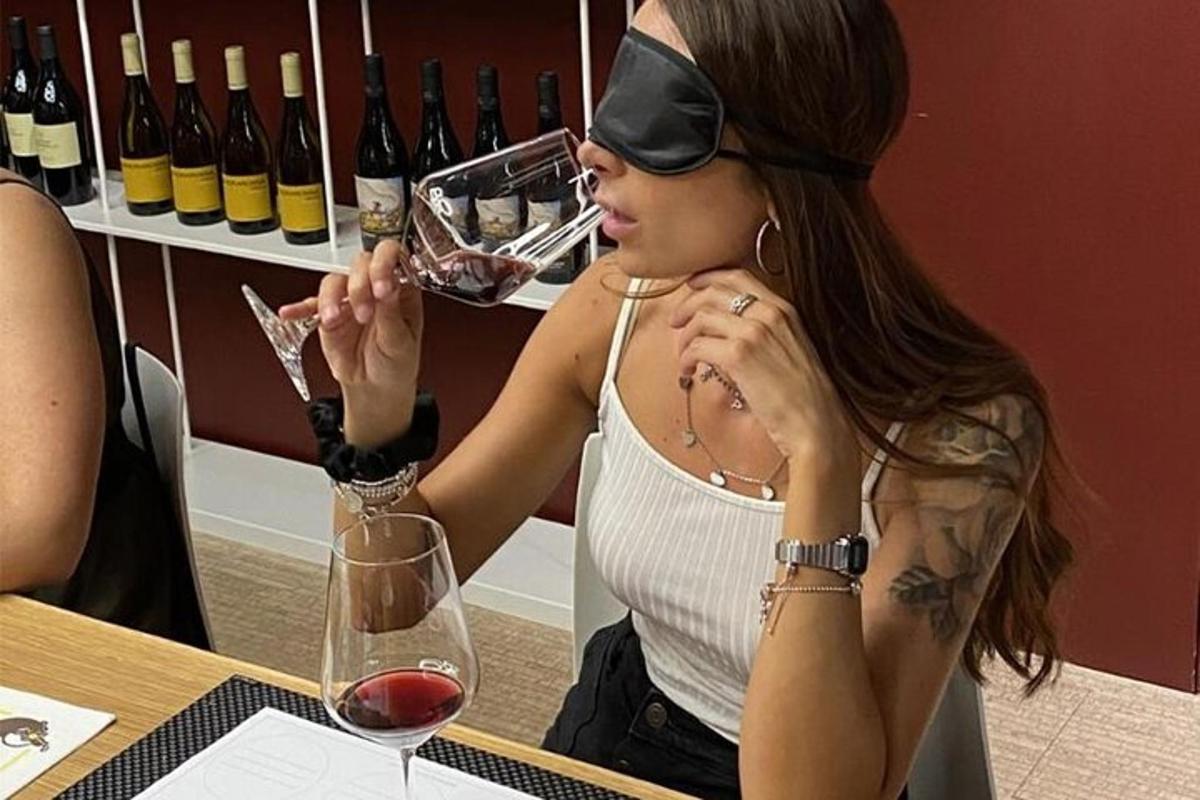 a woman sitting at a table with a glass of wine