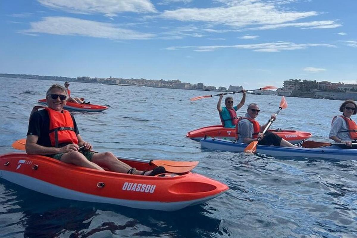een groep mensen in kajaks op het water