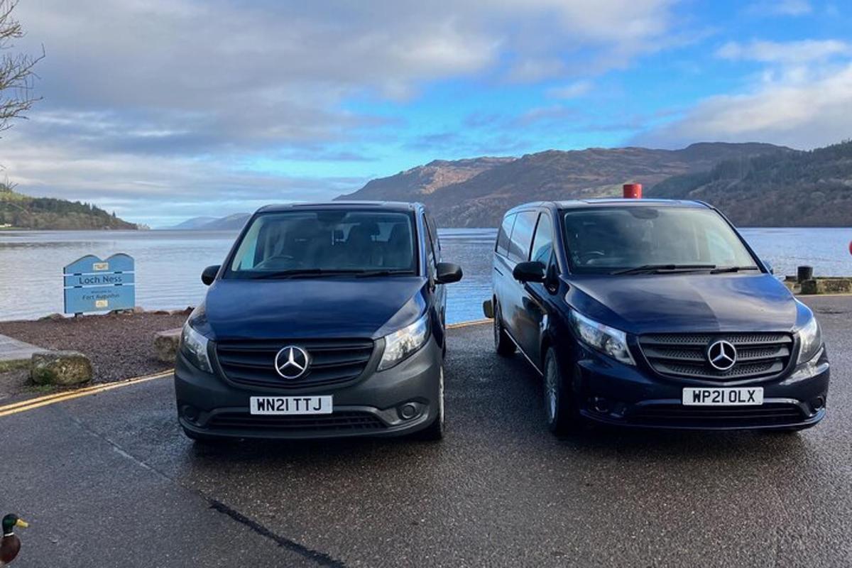 two cars parked next to a body of water