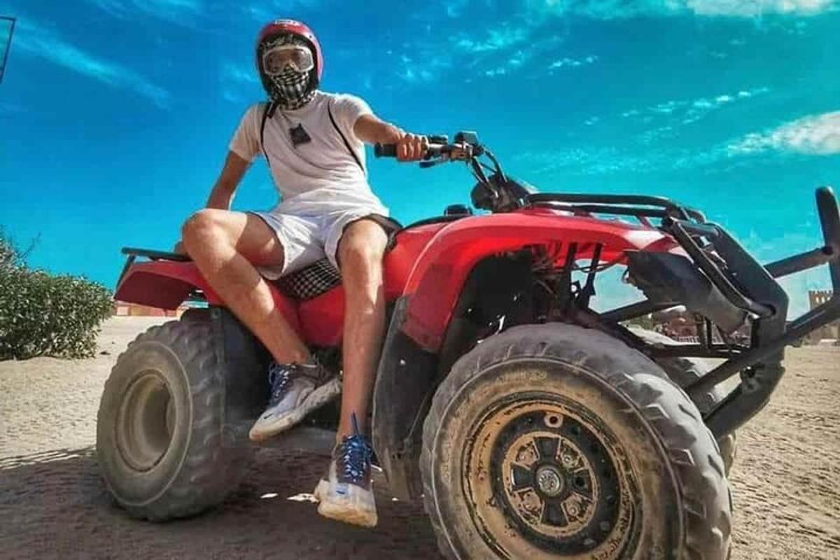 Mees istub rannas punasel ATV-l