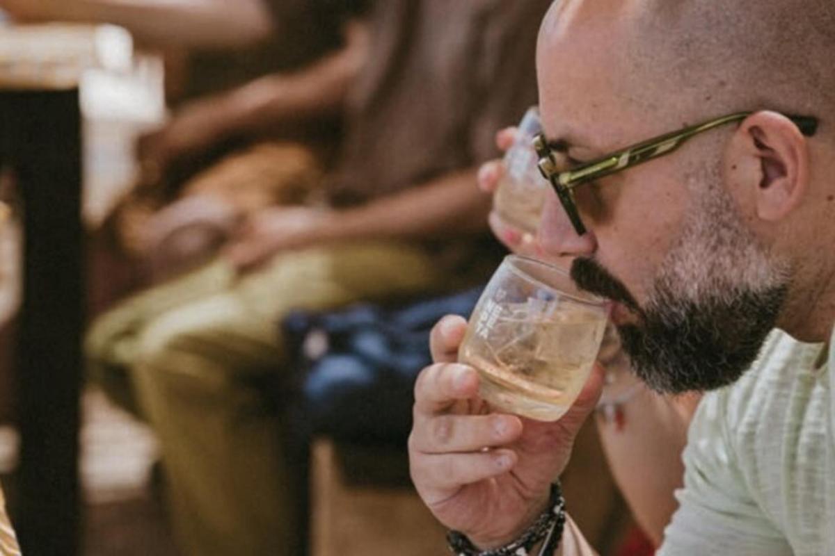 Un hombre con gafas bebiendo un vaso de cerveza