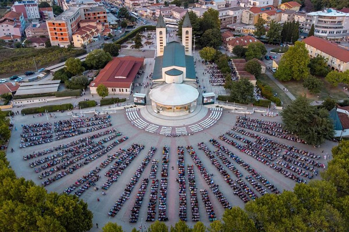 an aerial view of a large crowd of cars in a parking lot