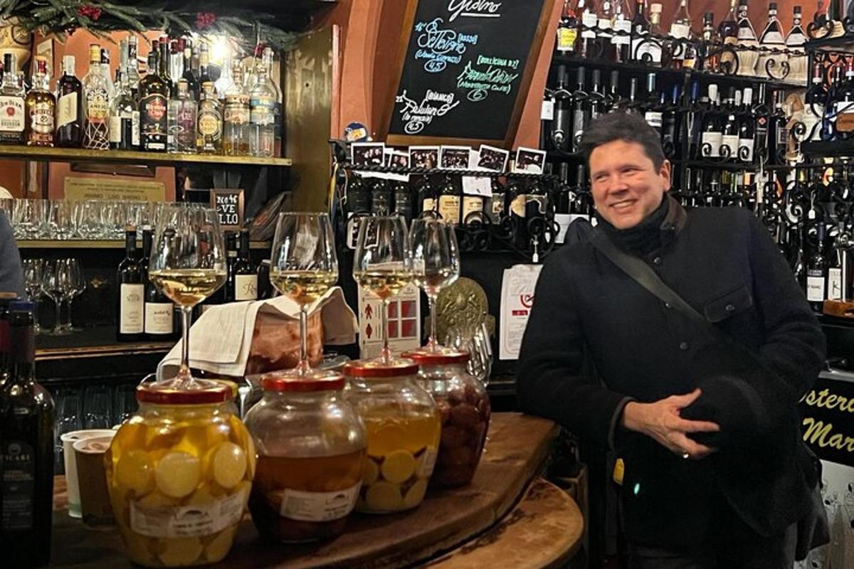 en mann som står bak en bar med glass vin