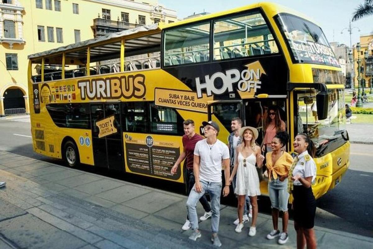 skupina lidí stojících před dvoupatrovým autobusem