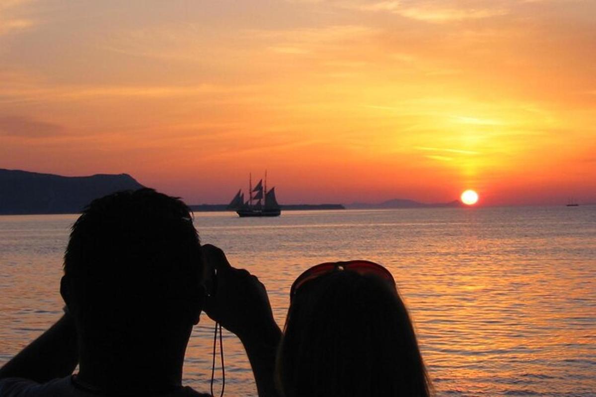 un parell de persones fent una foto de la posta de sol