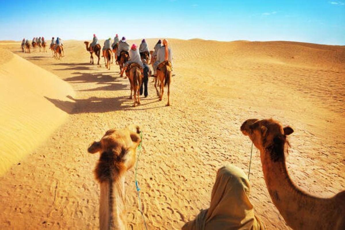 eine Gruppe von Menschen reitet in der Wüste