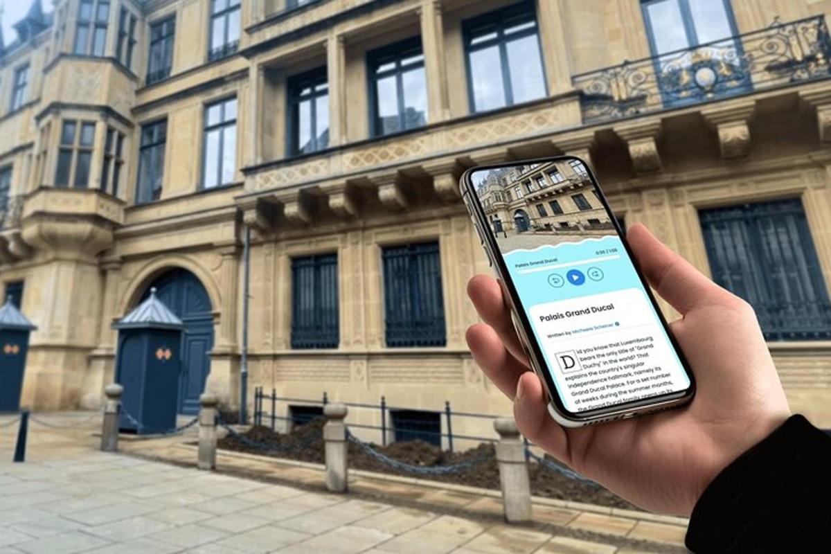 una persona che tiene in mano un telefono cellulare davanti a un edificio