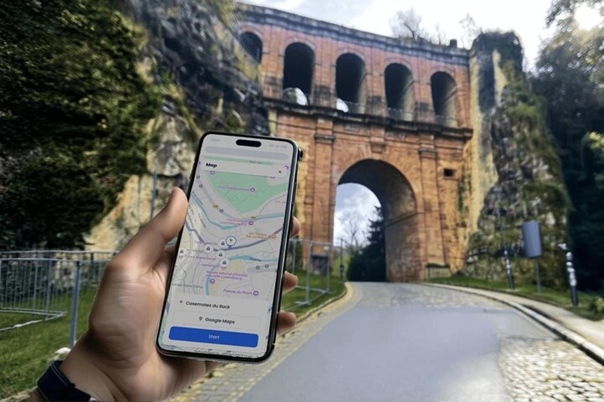 una persona che tiene in mano un cellulare davanti a un ponte