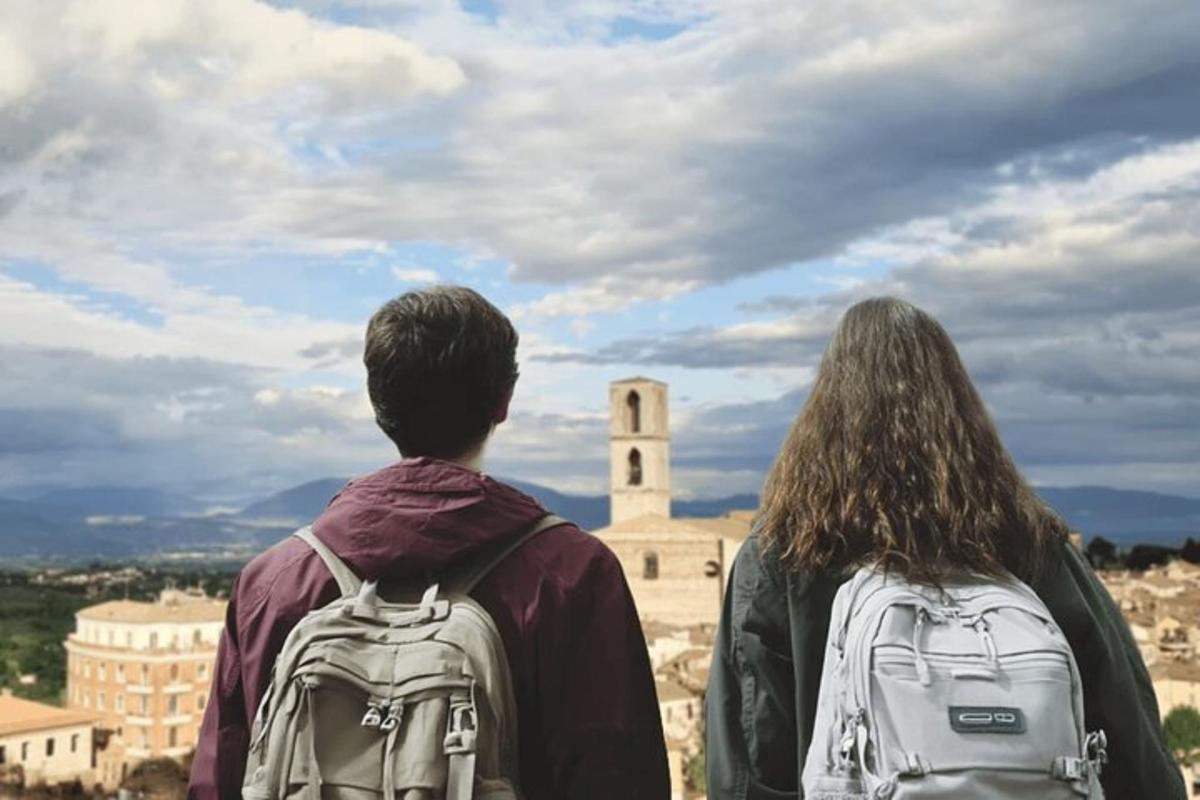 Un hombre y una mujer con mochilas mirando un castillo.