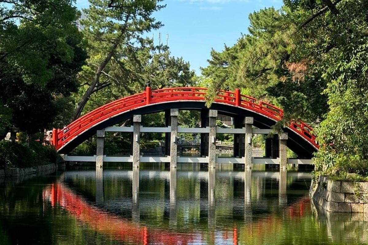 un ponte rosso sopra un fiume in un parco