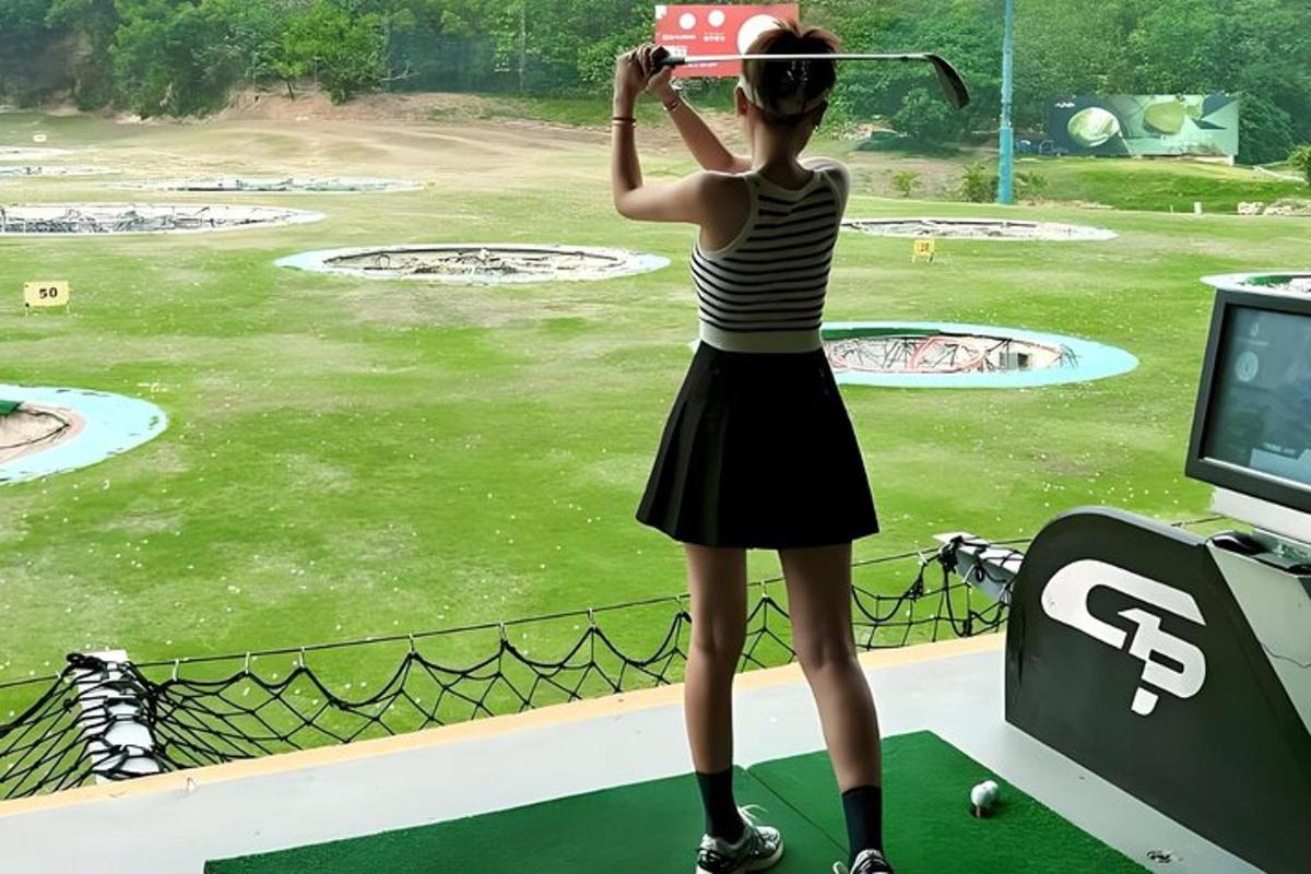 a woman is standing in front of a golf simulator