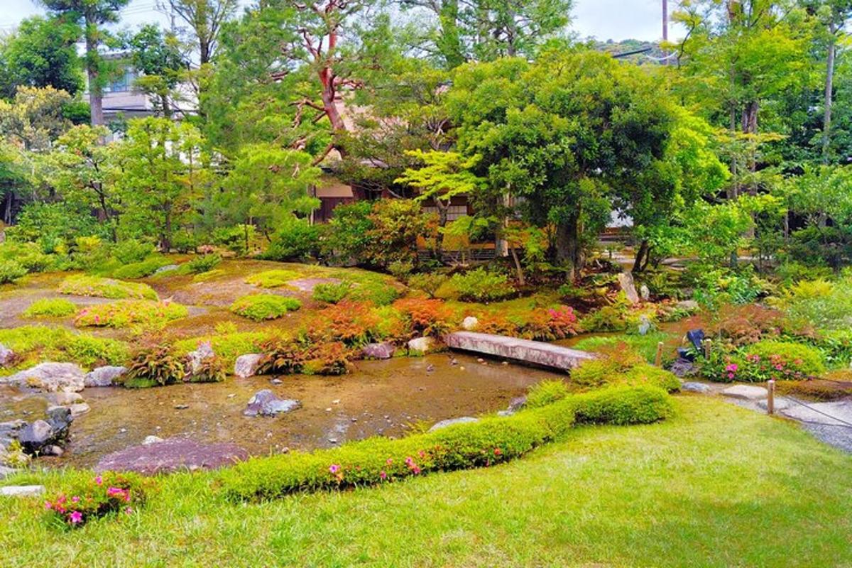 ein Garten mit einem Teich und vielen Blumen und Bäumen