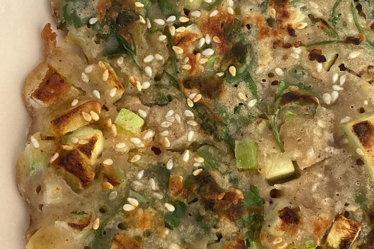 pizza dengan biji bijan dan sayur-sayuran di atas pinggan