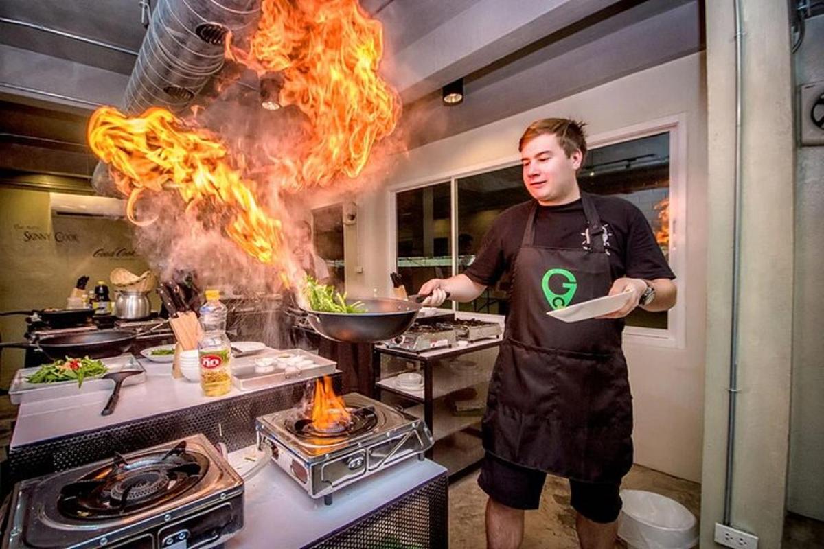 un uomo in cucina che prepara il cibo in un wok