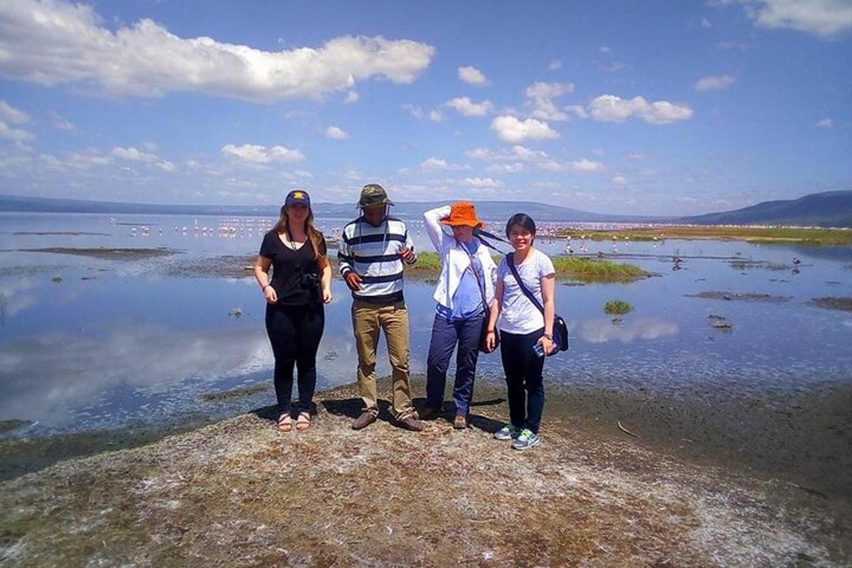 skupina lidí stojících na skále u vody