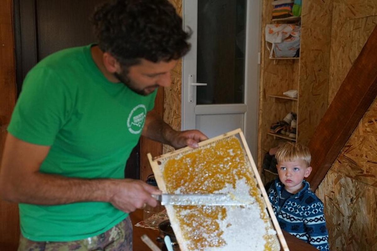 a man is cutting a cake with a boy