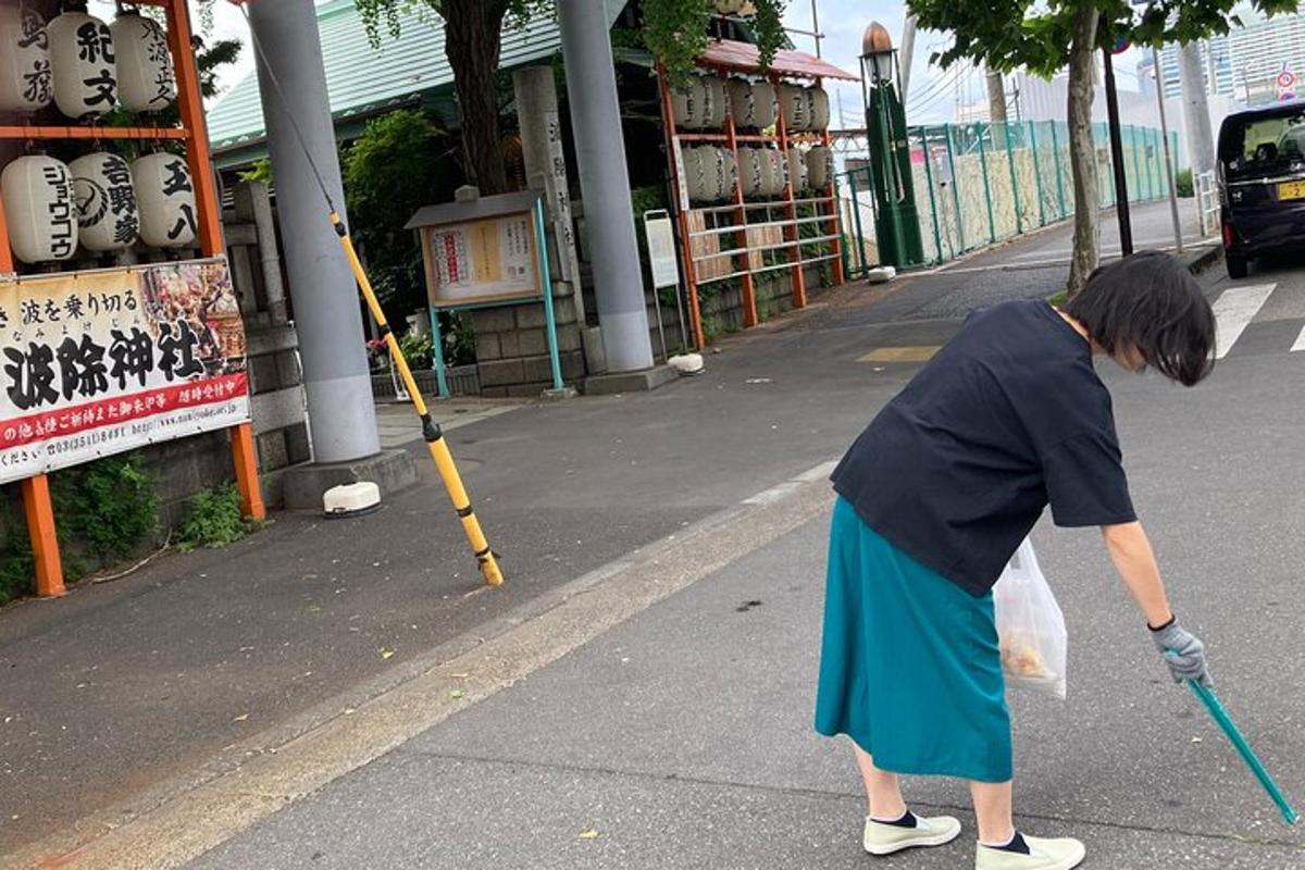 žena kráčející po ulici s koštětem