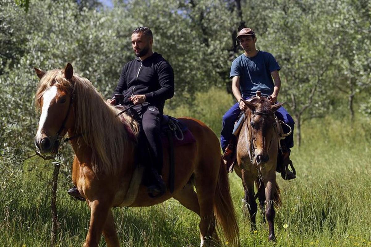 dois homens cavalgando em um campo