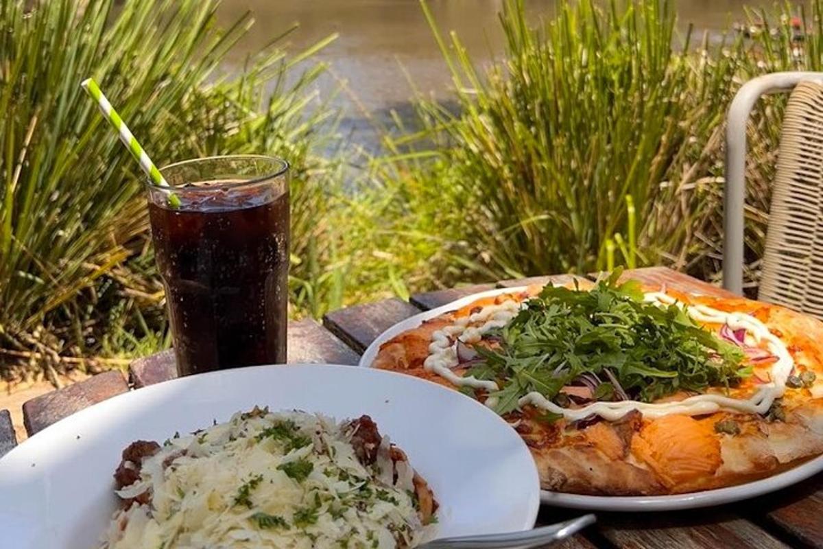 a table with a plate of pizza and a drink