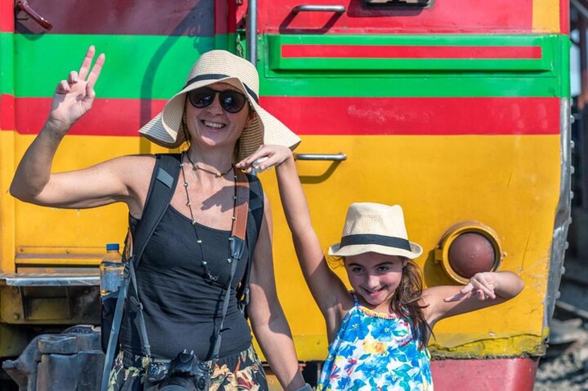 uma mulher e uma menina em pé ao lado de um trem