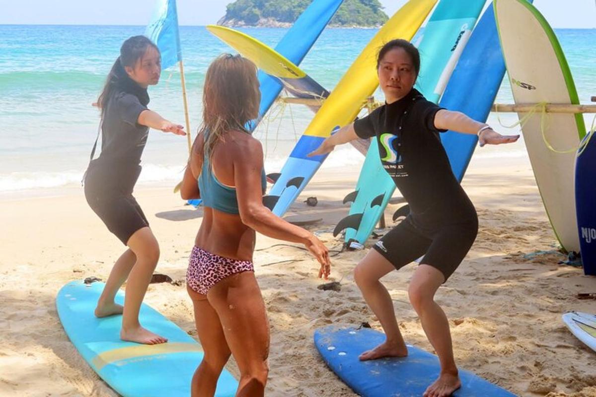 Grupa ludzi stojących na deskach surfingowych na plaży