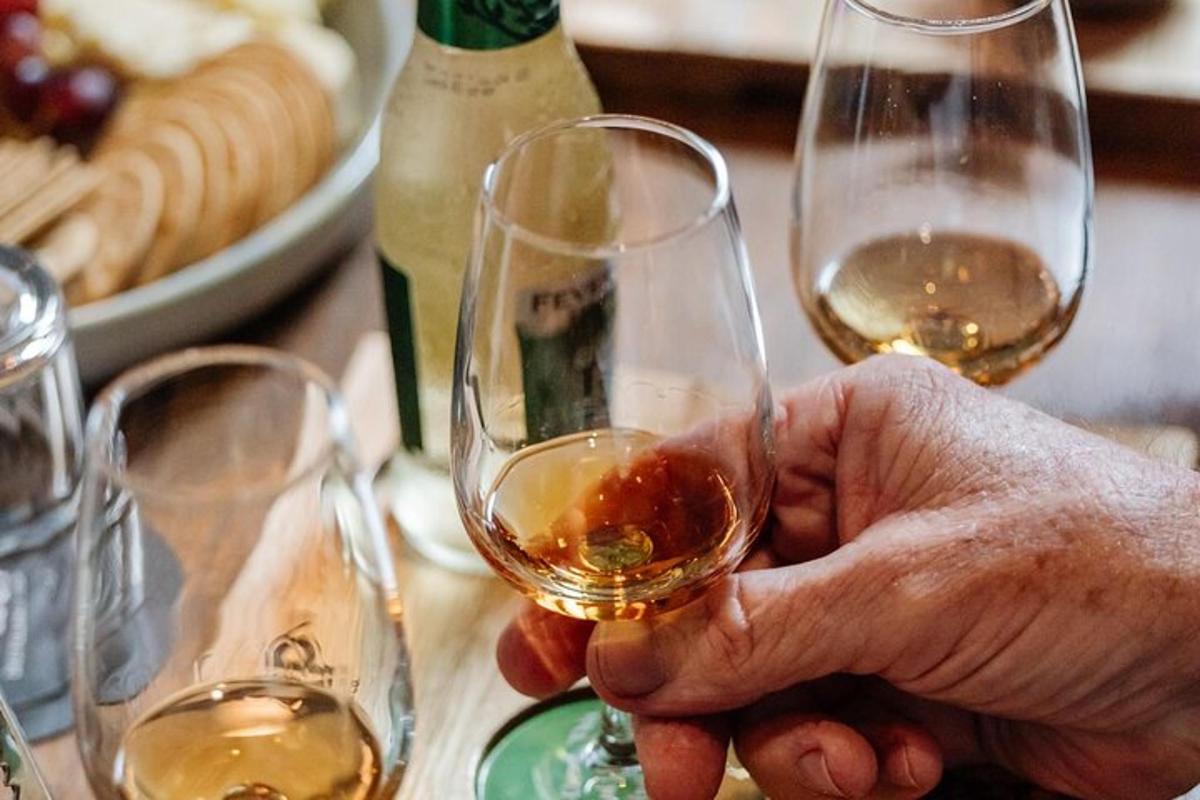 eine Person, die ein Glas Wein auf einem Tisch hält