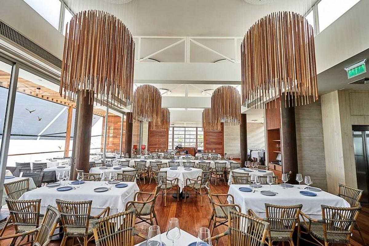 Un salón de banquetes con mesas y sillas blancas y candelabros.