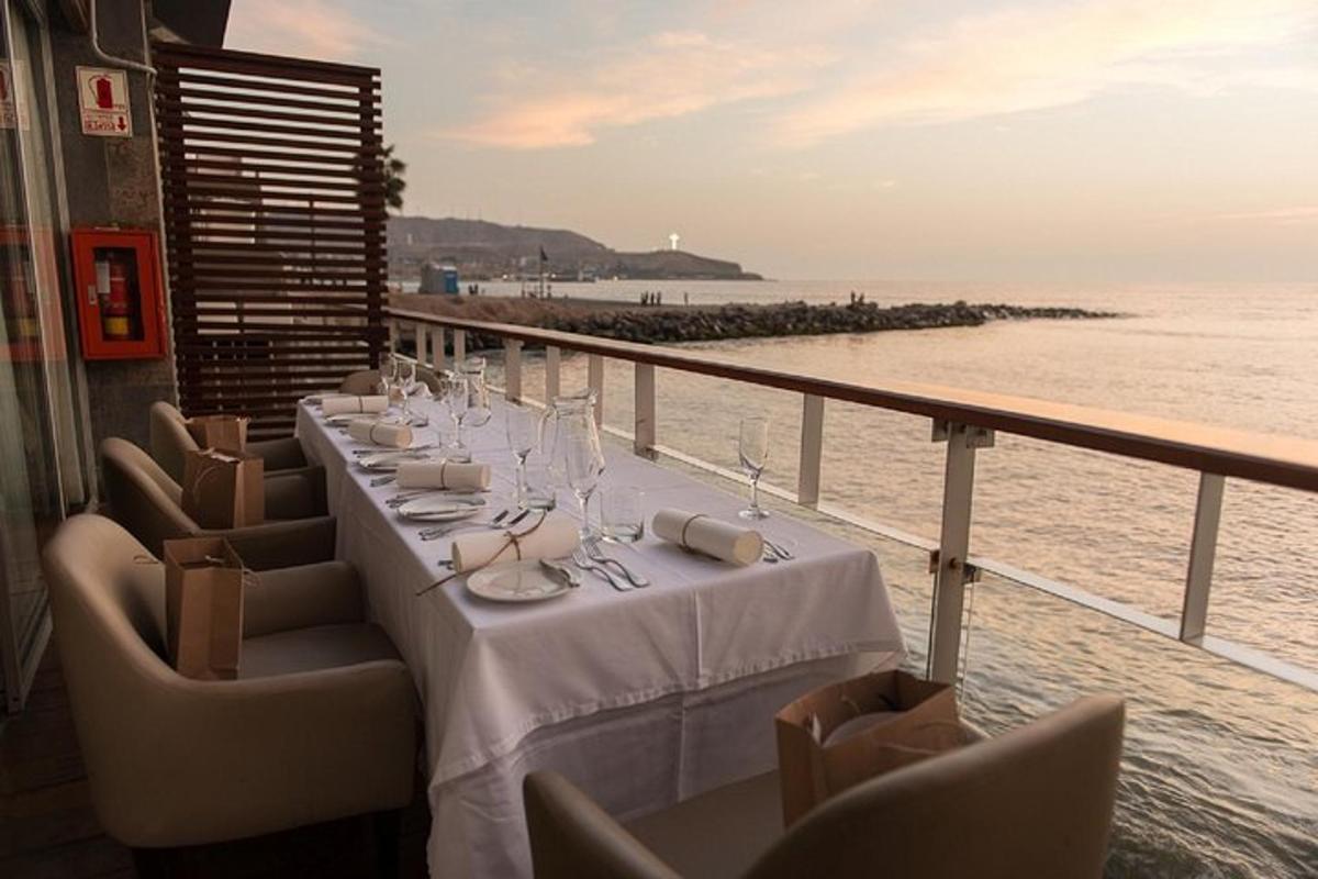 Una mesa en un balcón con vista al mar.