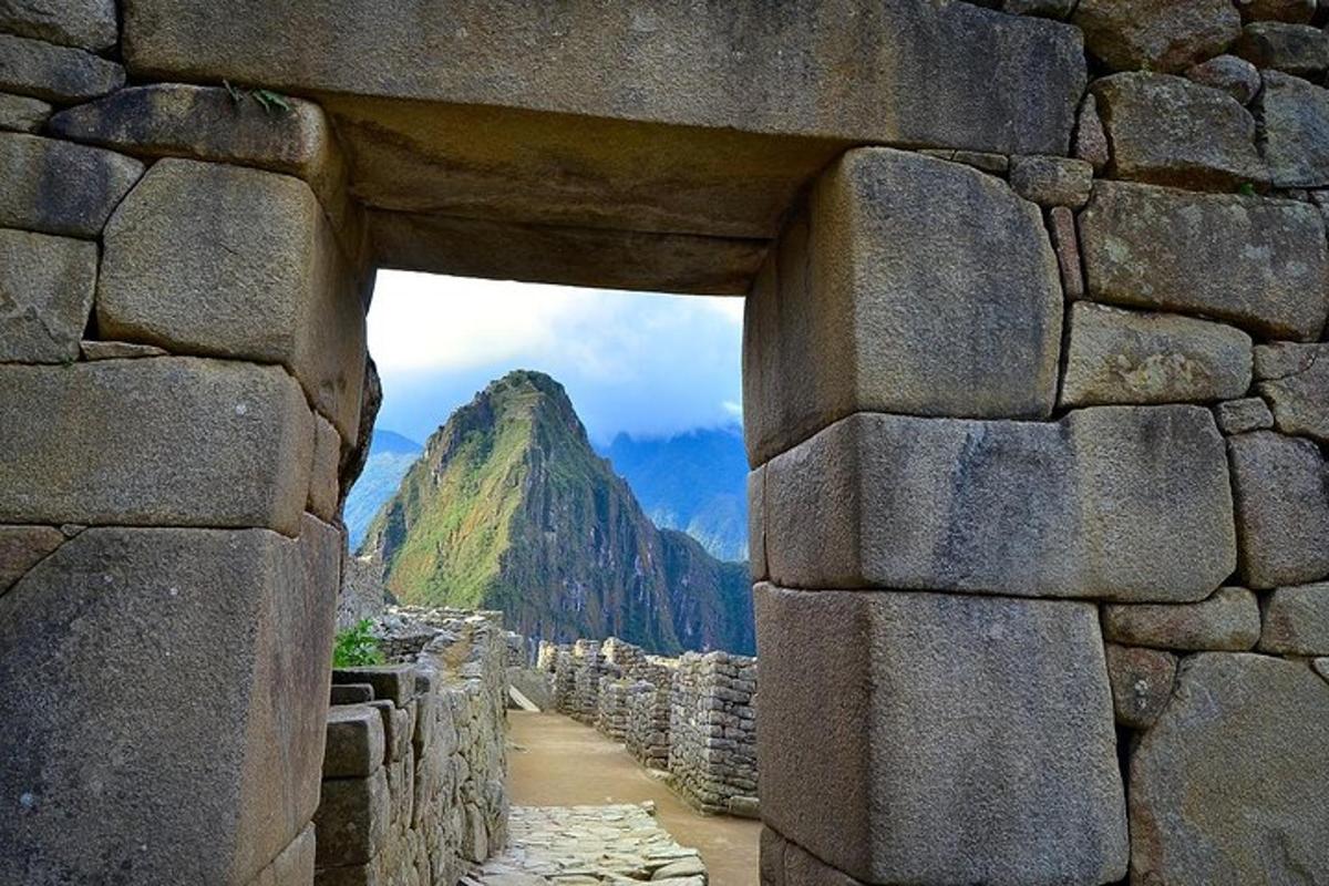 una vista di una montagna attraverso un muro di pietra