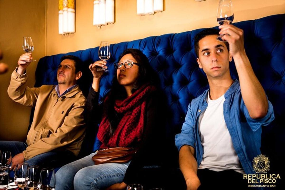 um grupo de pessoas sentadas em um sofá segurando taças de vinho