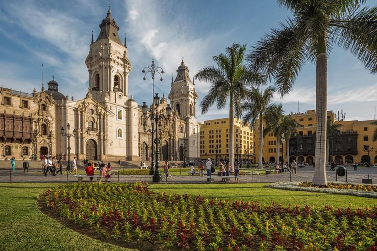 a large building with a clock tower and palm trees
