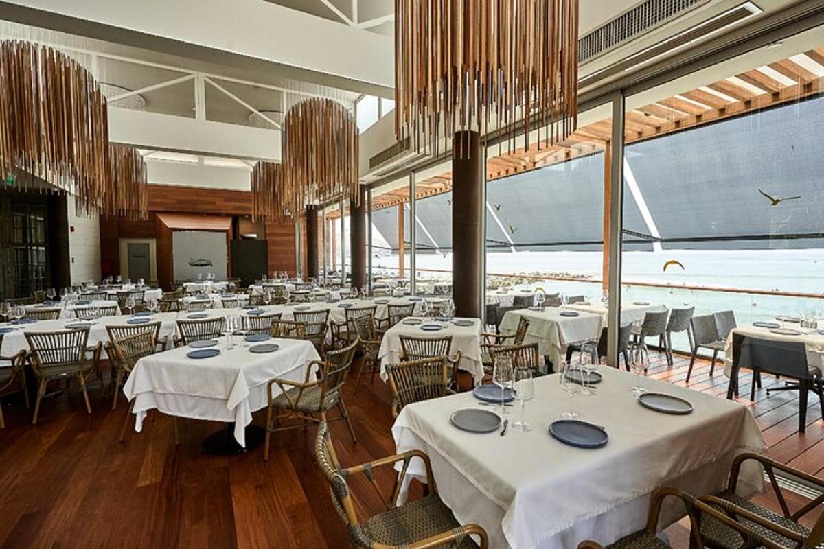 a dining room with tables and chairs with white table cloth
