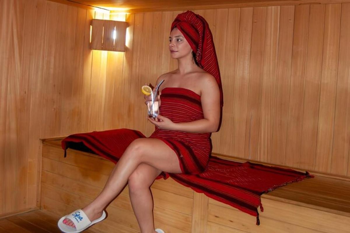 Una mujer con un vestido rojo sentada sobre una toalla