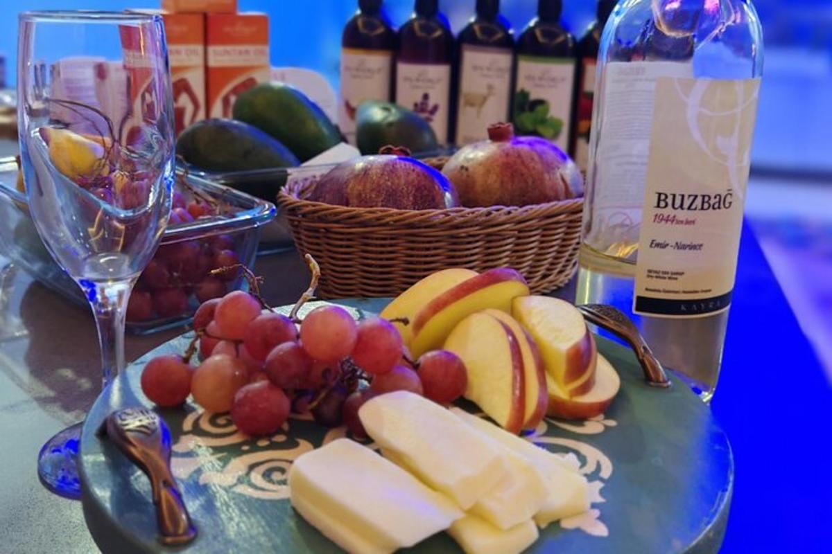 Un plato de fruta y botellas de vino sobre una mesa.