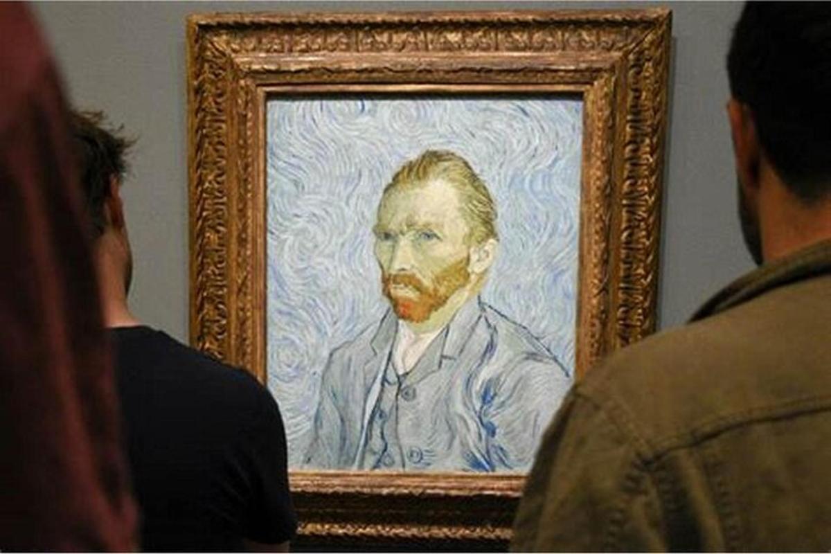 a man looking at a painting of an older man