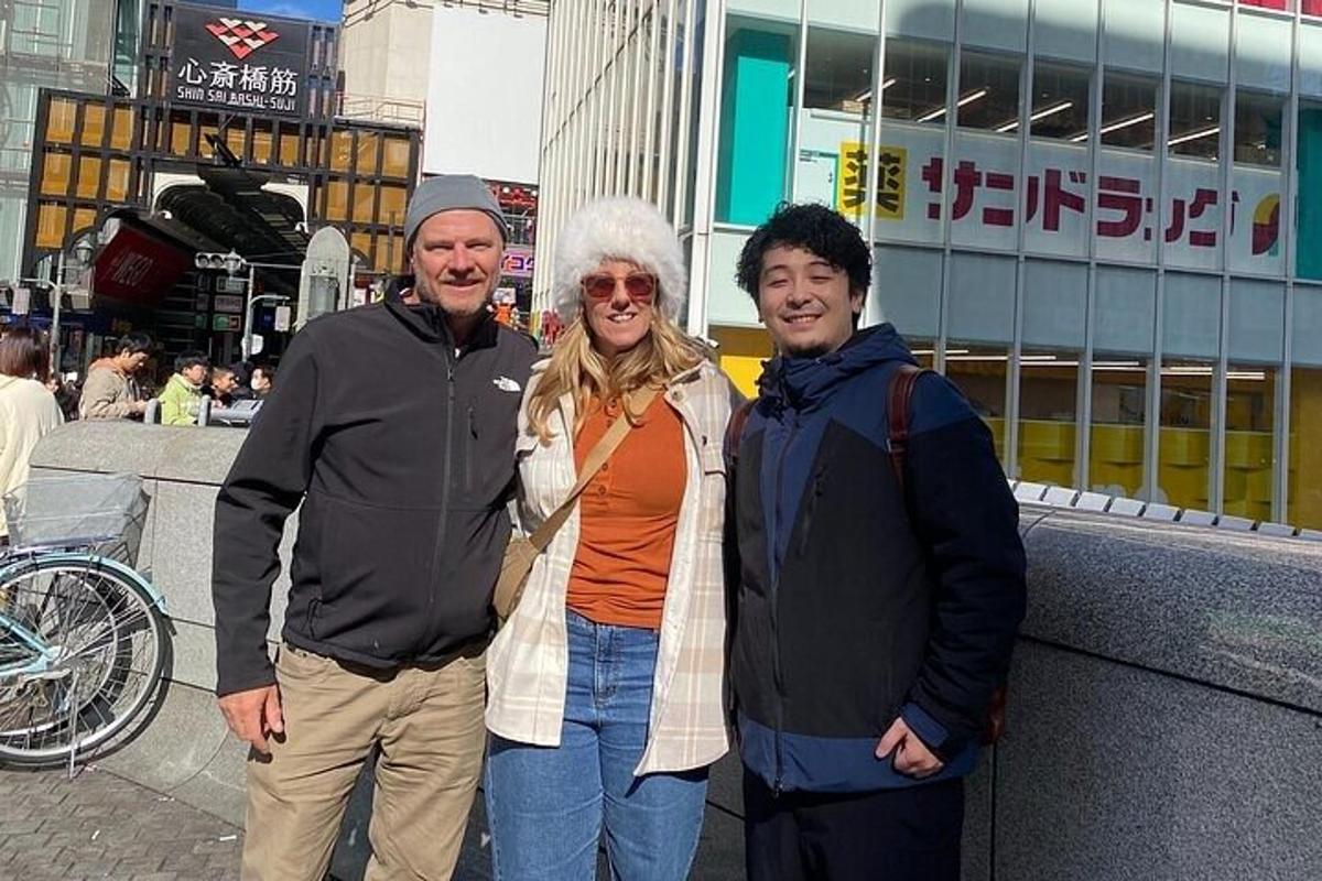 two men and a woman standing next to a building