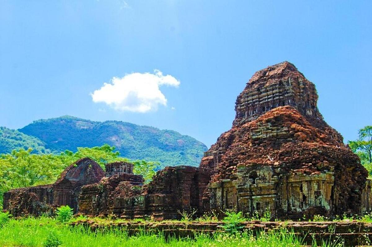 um edifício antigo em um campo com montanhas ao fundo