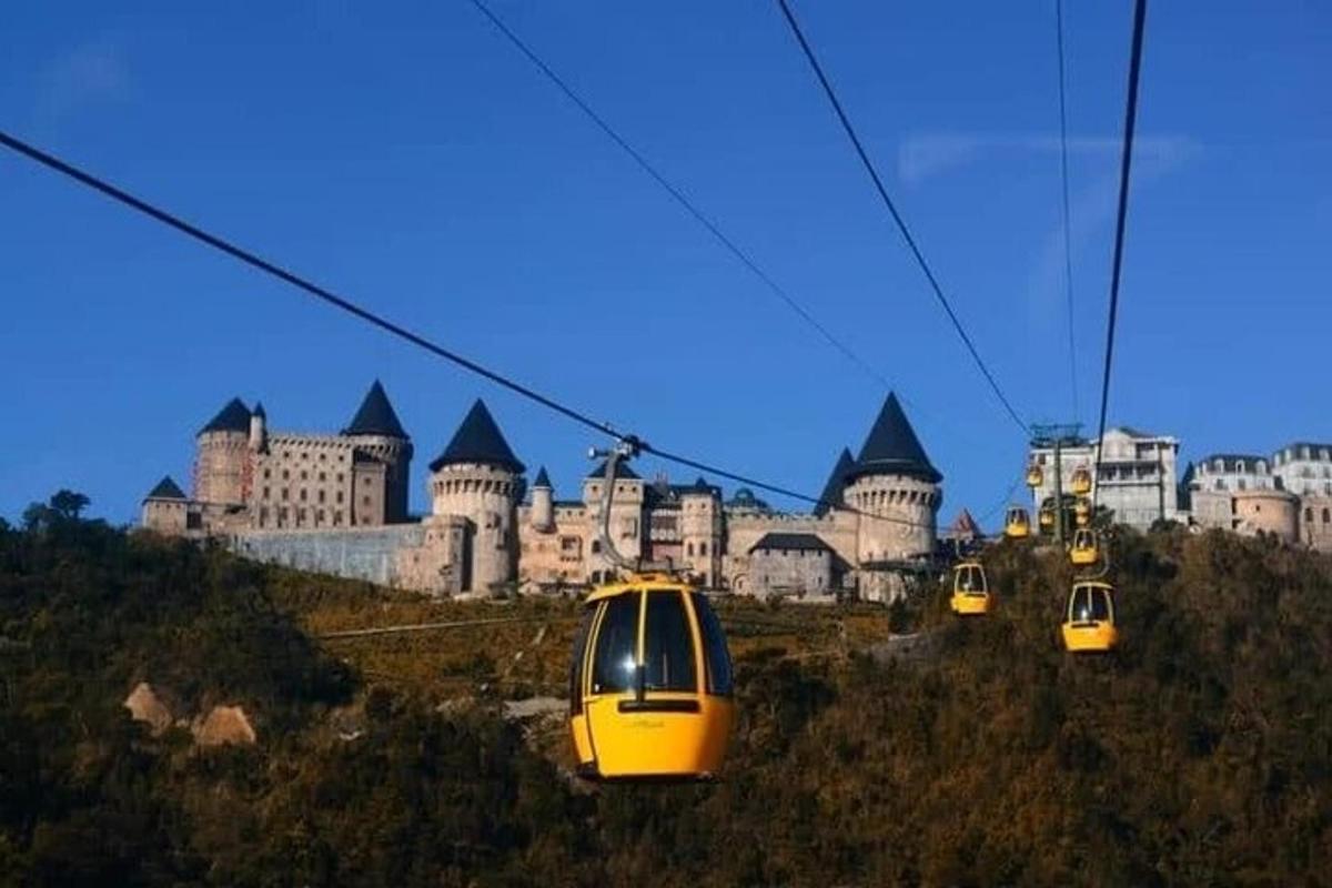 três teleféricos amarelos em frente a um castelo