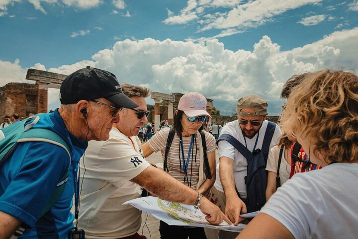 un grup de oameni care stau în jurul unui bărbat care ține o hârtie