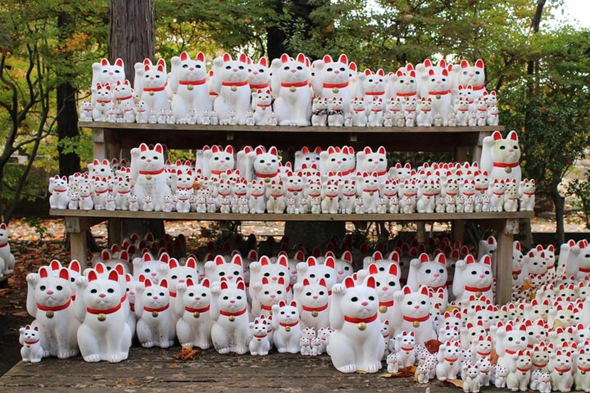 een groep witte kattenbeeldjes staat op een rij