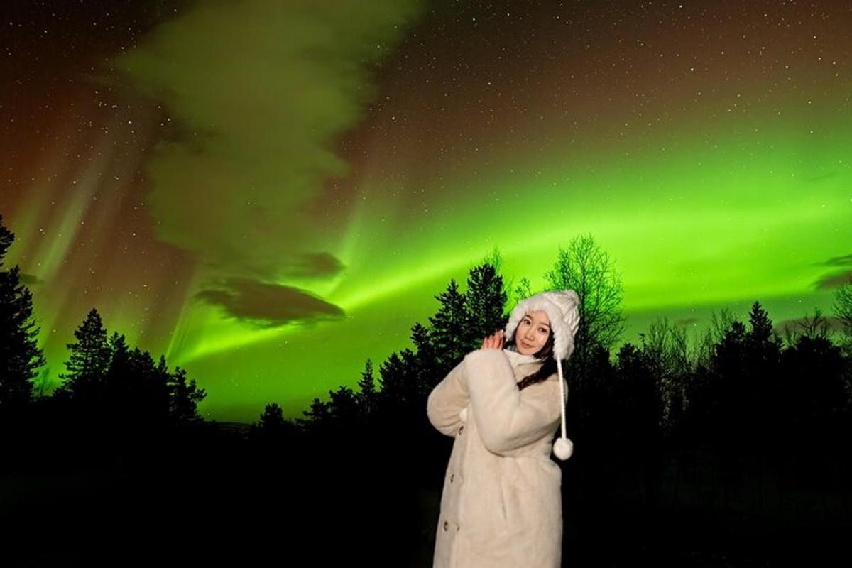 una donna è in piedi davanti all'aurora boreale