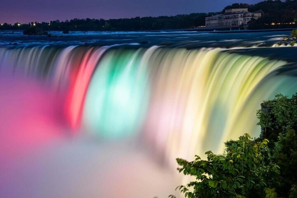 a large waterfall with a rainbow at night