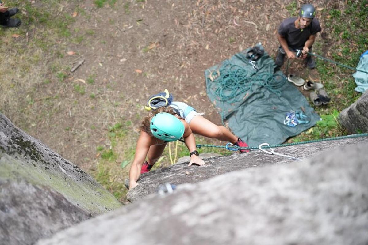 a woman climbing on a rock with a helmet on