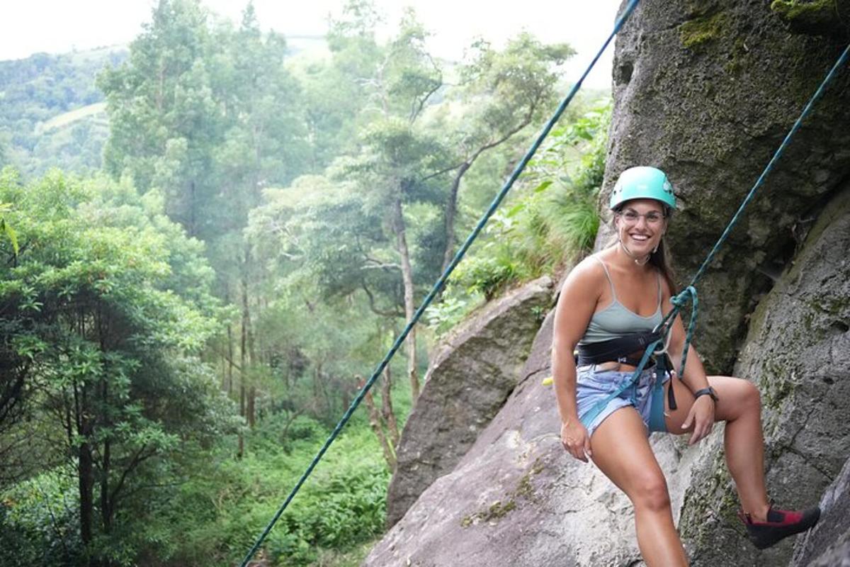 a woman sitting on a rope on a rock wall