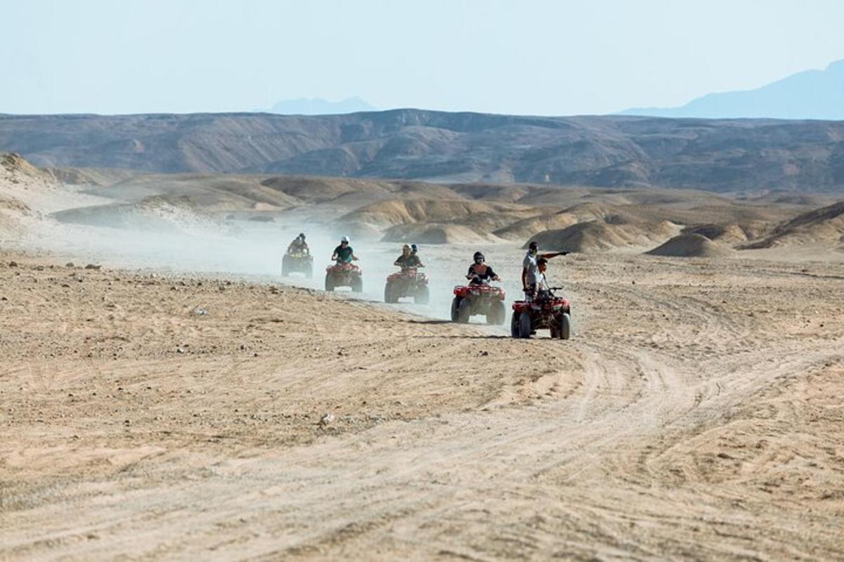 un gruppo di persone che guidano quad nel deserto
