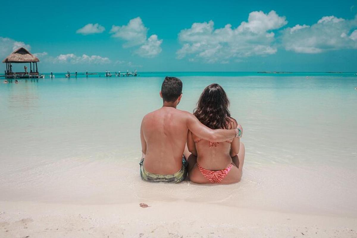 Un hombre y una mujer sentados en el agua en una playa