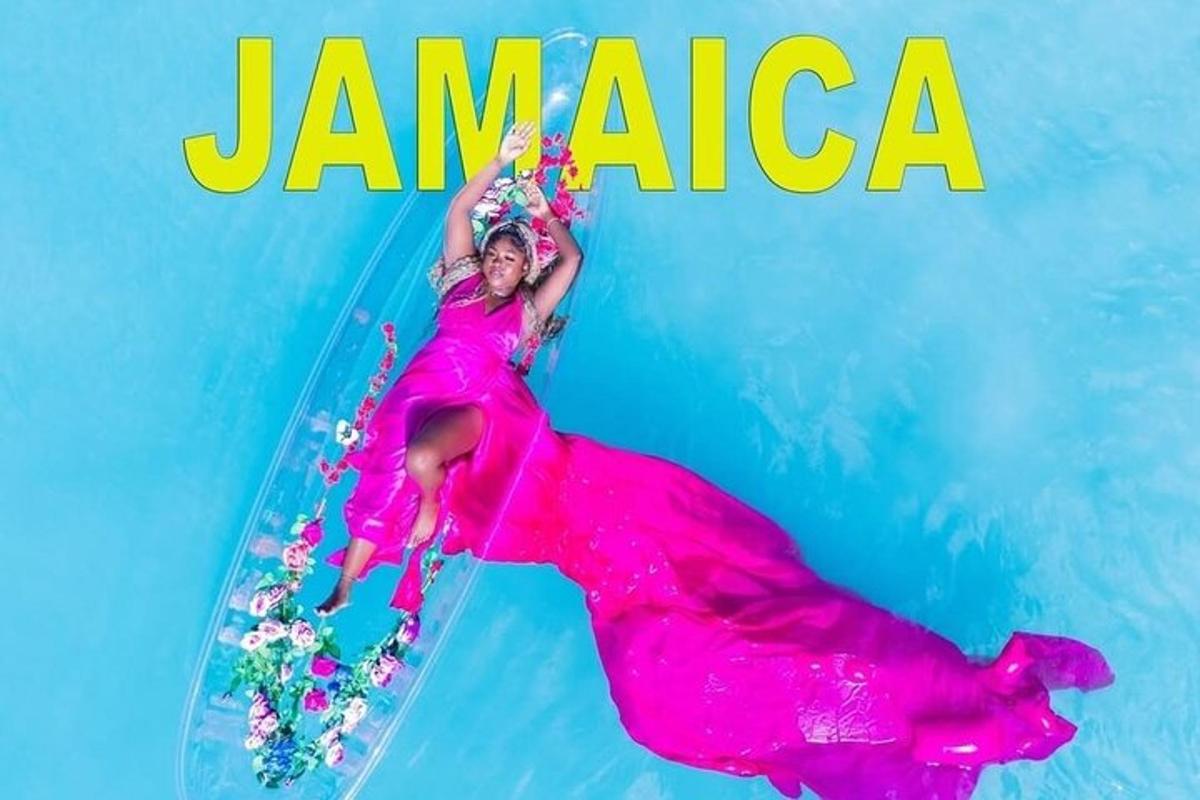 Una mujer con un vestido rosa recostada sobre una tabla de surf