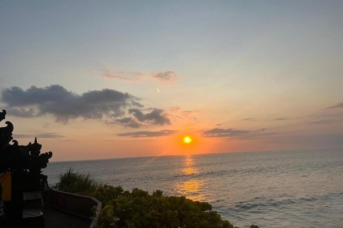 Una puesta de sol sobre el océano con el sol en el cielo.
