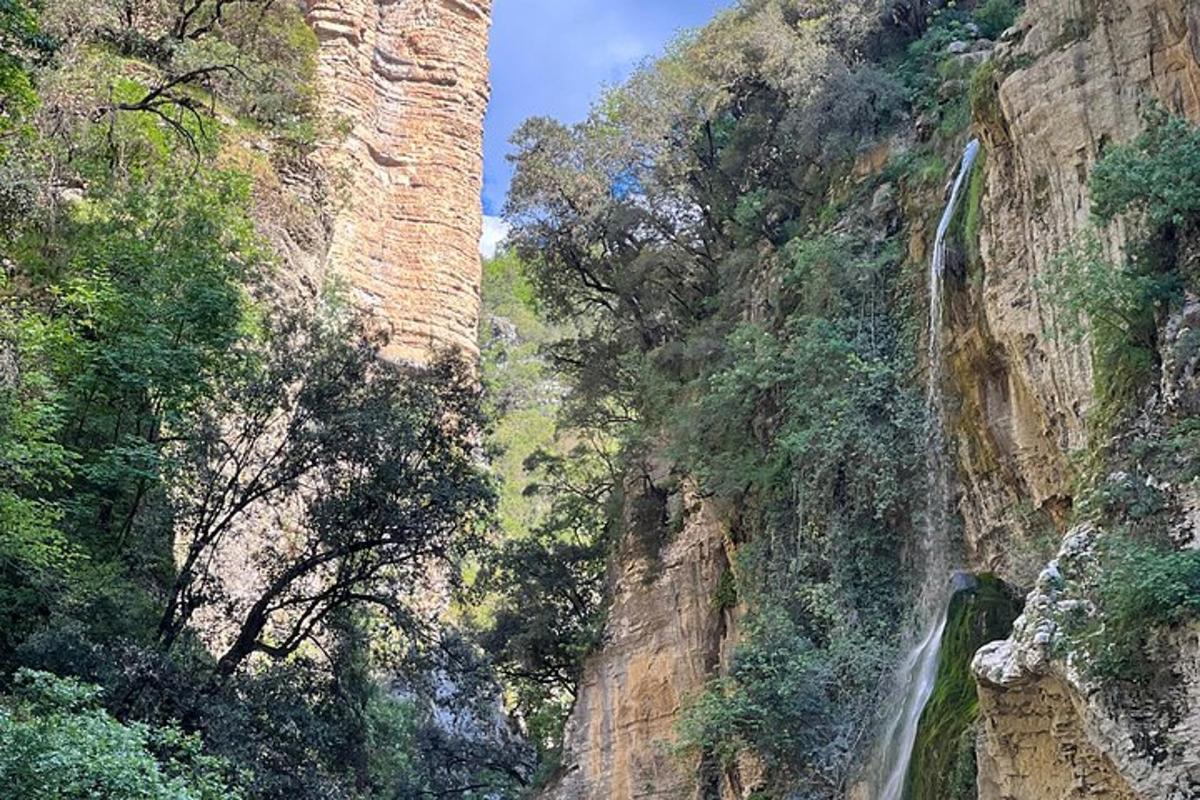 a canyon with a waterfall on the side of a mountain