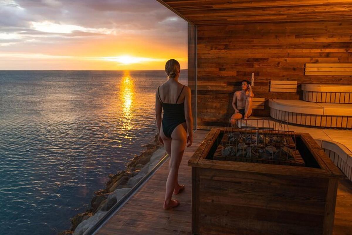 una donna in piedi su un ponte che guarda il tramonto